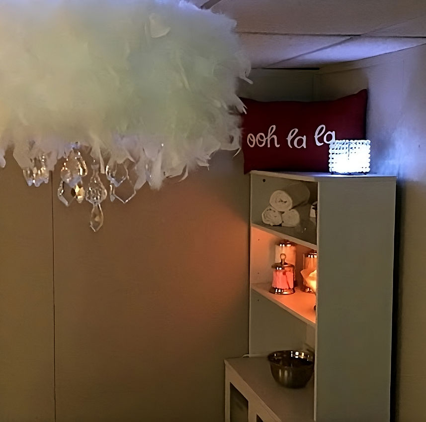 A white feather chandelier hanging elegantly from the ceiling in a beautifully decorated room.