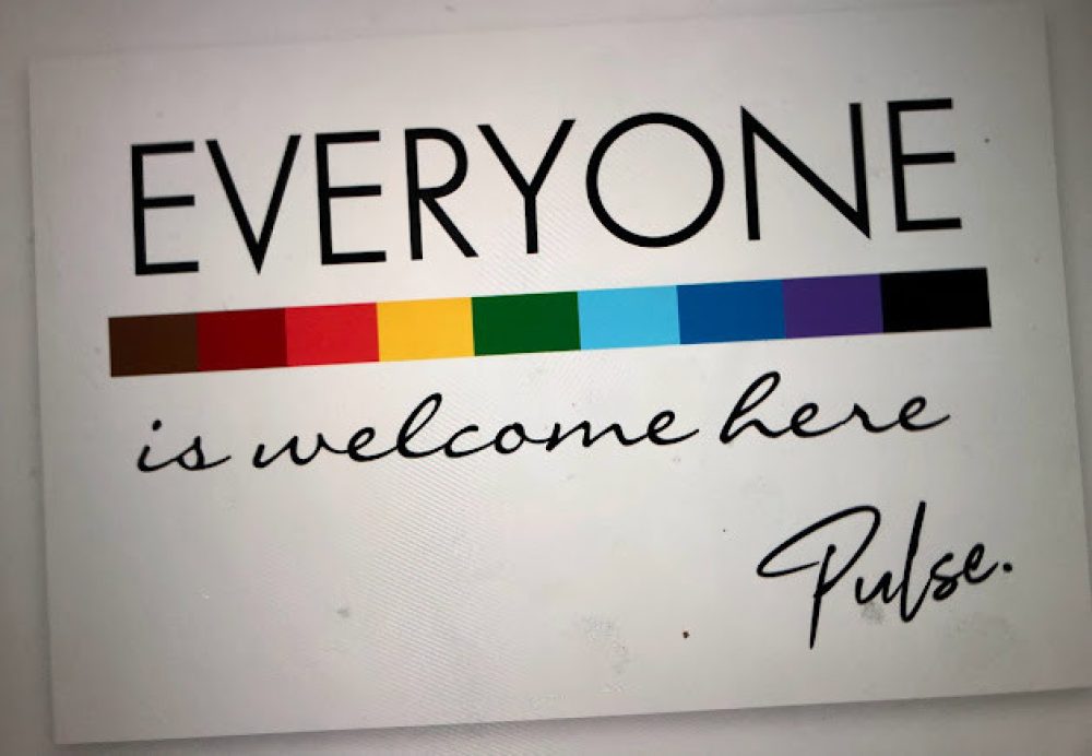 Inclusive sign with diverse group of people, text reads "everyone is welcome here".